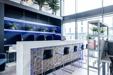 a counter with chairs and plants in front of it