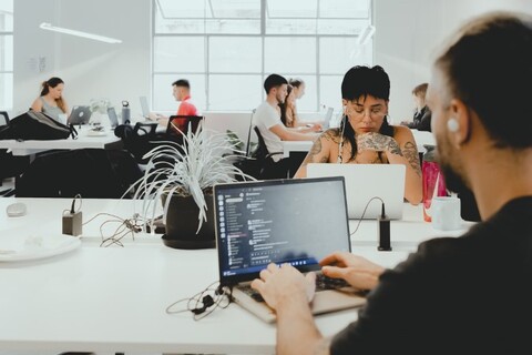 a group of people looking at a laptop