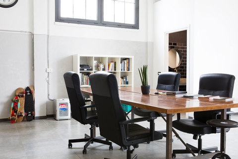 a desk with a computer and a chair in a room