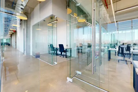 glass walls of a room with a desk and chairs