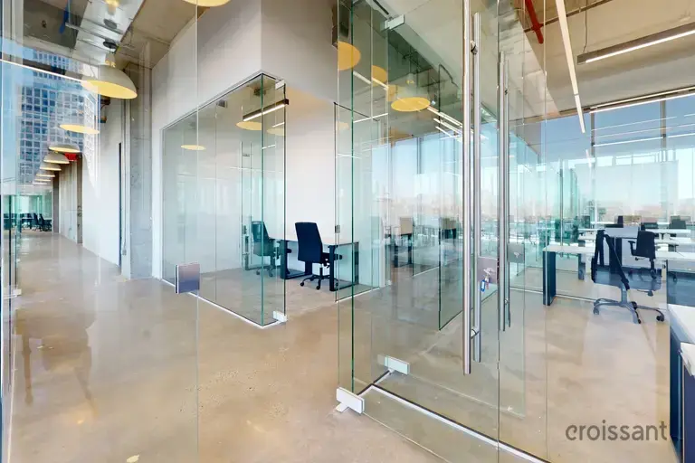 glass walls of a room with a desk and chairs