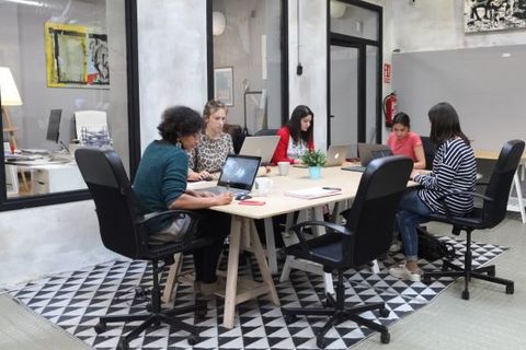 a group of people sitting at a desk with a laptop