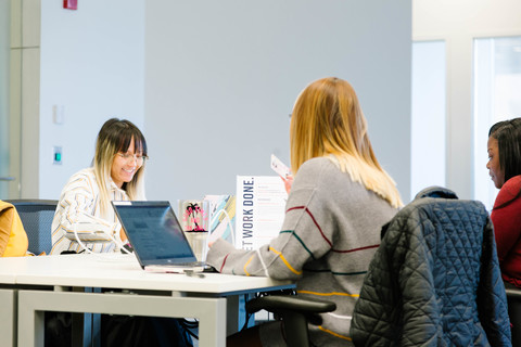 a group of people looking at a laptop