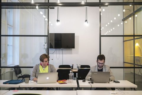 a person sitting at a desk in front of a computer