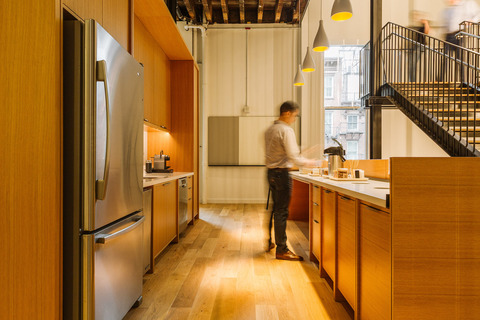 a person standing in front of a refrigerator in a kitchen