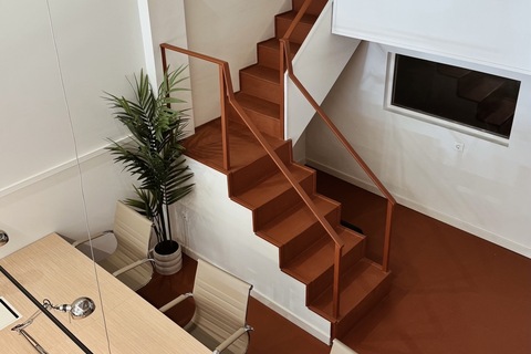 a room with a desk and stairs