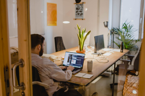 a person sitting at a table in front of a window