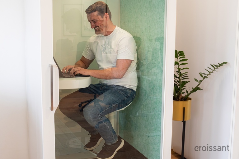 a man sitting in a booth with a laptop
