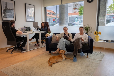 a group of people sitting on a couch in a room with a dog