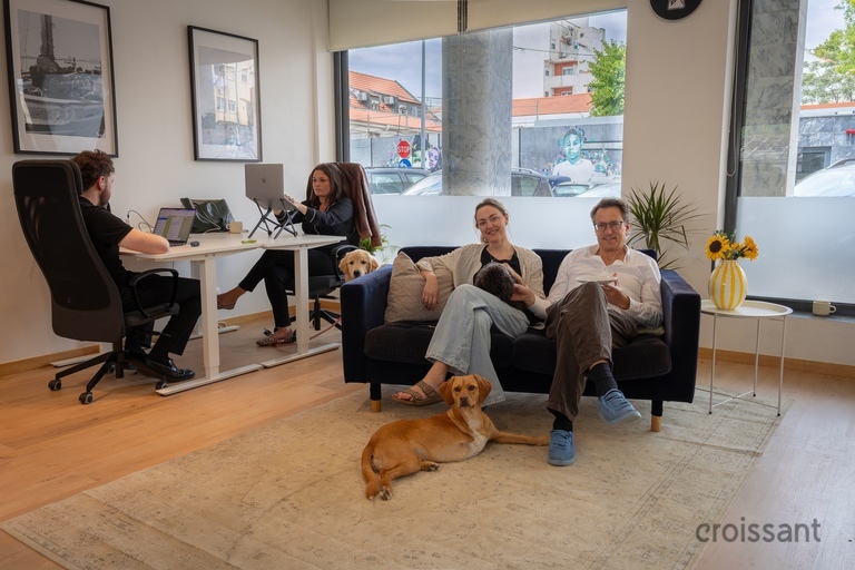 a group of people sitting on a couch in a room with a dog