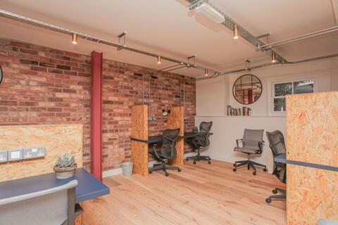 a room with chairs and a brick wall