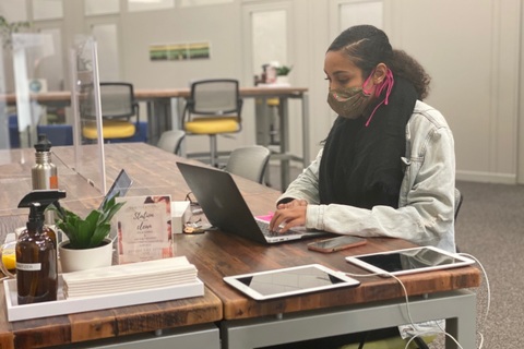 a person sitting at a table using a laptop
