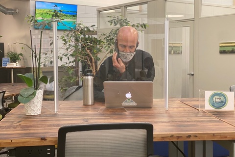 a man sitting at a table using a laptop
