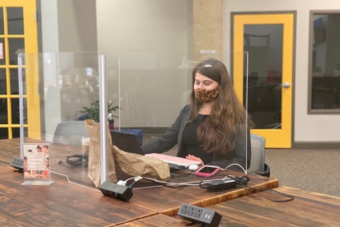 a person sitting at a table using a laptop