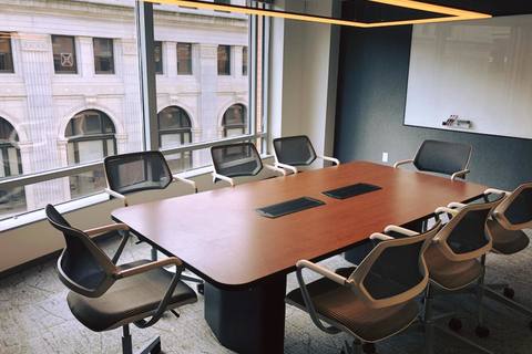 a desk with a computer in an office chair