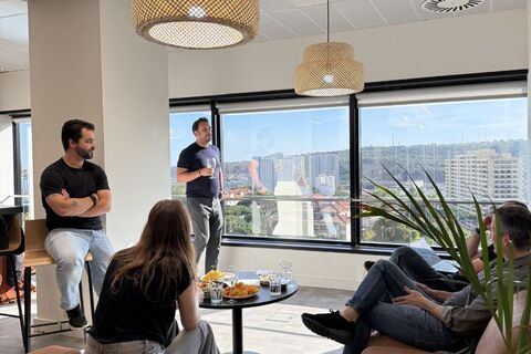 a group of people sitting in a room with a man standing in front of them
