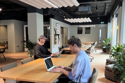 a man sitting at a table with a laptop