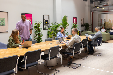 a group of people sitting at a desk in an office chair