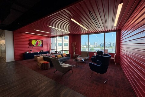 a room with red walls and a red wall with a couch and chairs