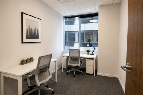 a room with a desk and chairs