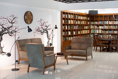 a living room filled with furniture and a table in a library