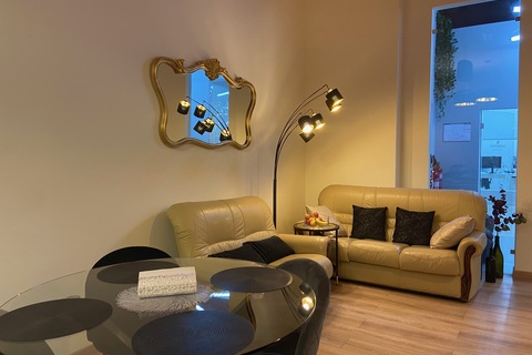a living room with a couch a table and looking at the camera
