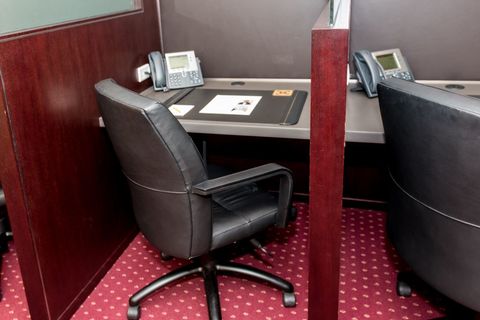 a desk with a laptop computer sitting on top of a chair