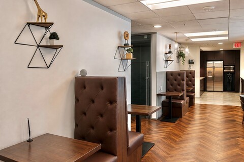 a room with brown booth seating and wooden tables