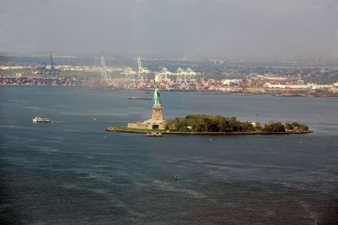 a large ship in a body of water with a city in the background