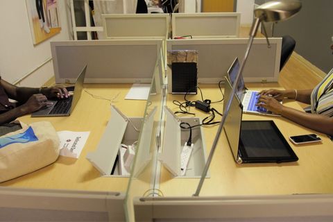 a person sitting at a table using a laptop computer