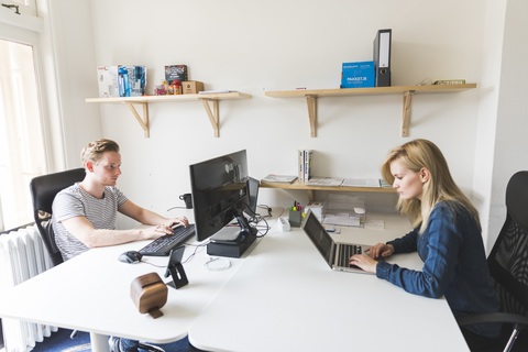 a woman sitting at a table using a laptop