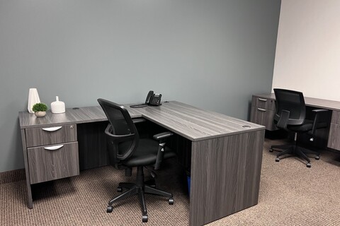 a bedroom with a desk and chair in a room