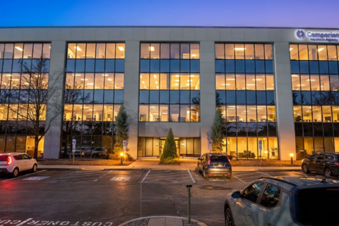 a building with many windows and cars parked in front of it