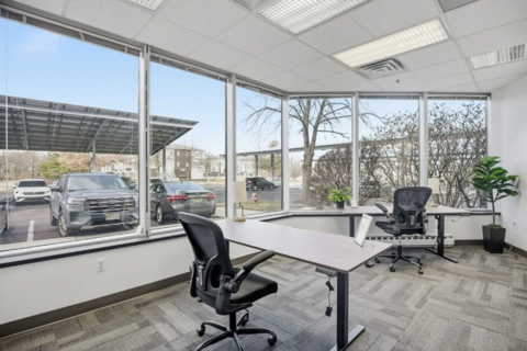 a room with a desk and chairs