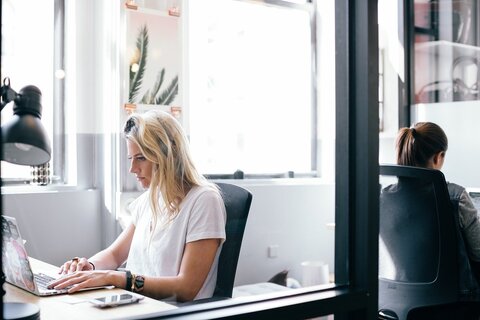 a woman sitting at a desk with a laptop