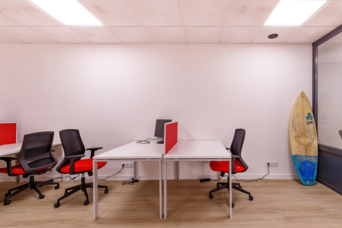 a desk with a computer and a chair in a room