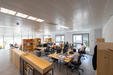 a group of people sitting at computers in an office