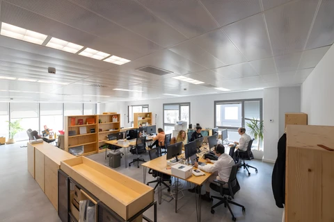 a group of people sitting at computers in an office