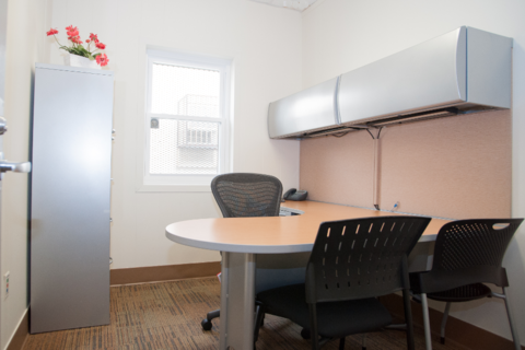 an office with a desk and chair in a room