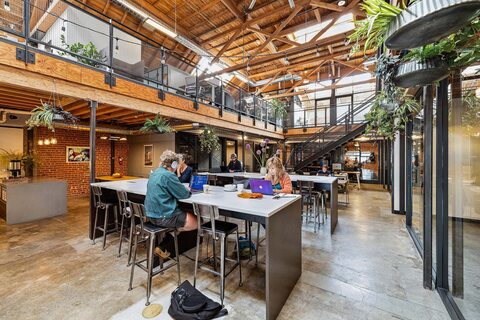 a group of people sitting at a table in front of a building
