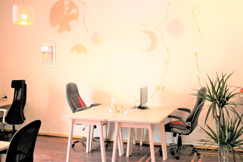 a desk with a computer and a chair in a room