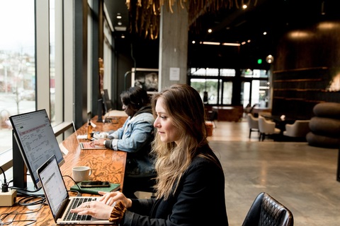 a person sitting at a table using a laptop