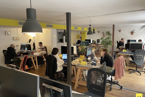 a group of people sitting at computers in an office