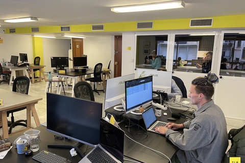 a man sitting at a desk with computers