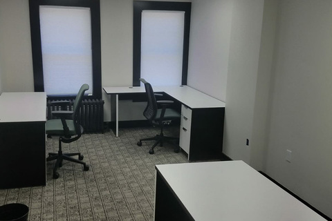 a bedroom with a bed and desk in a small room