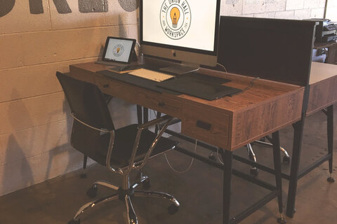 a desk with a computer and a tablet