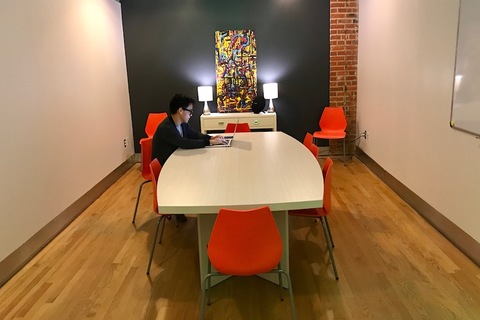 a desk with a laptop computer sitting on top of a wooden floor