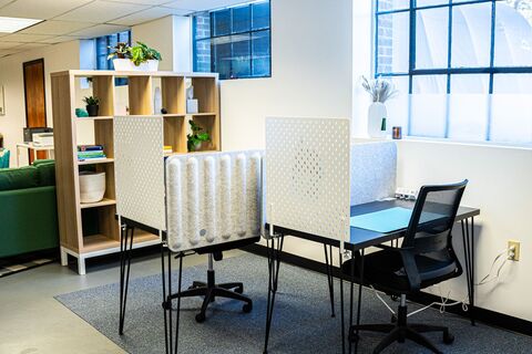 a room with a desk and chairs