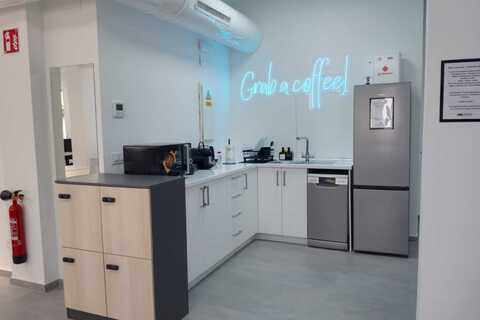 a kitchen with a refrigerator and a neon sign