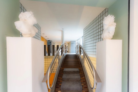 a staircase with a metal railing and a white statue